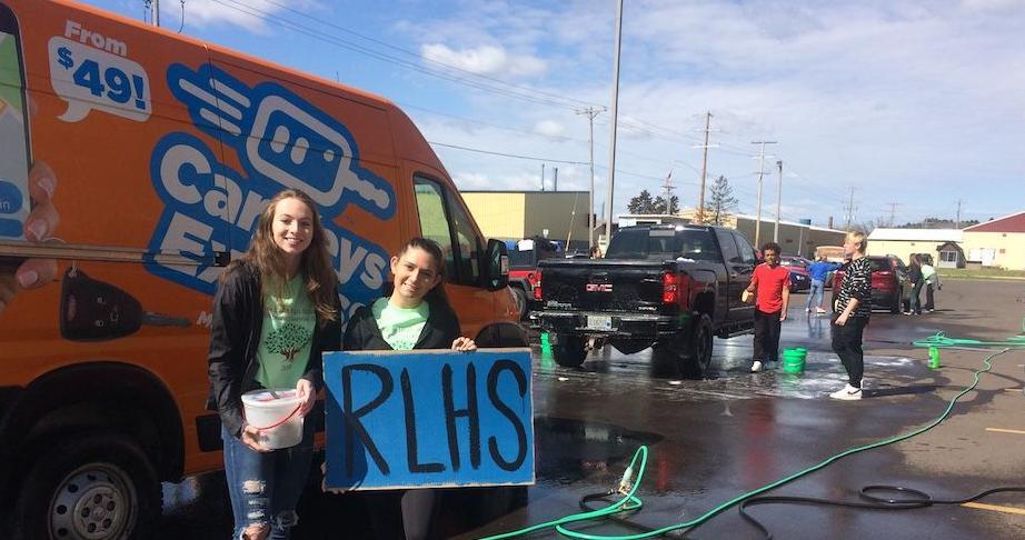 Morgan Hoff and Carley Widiker hold sign, donation bucket